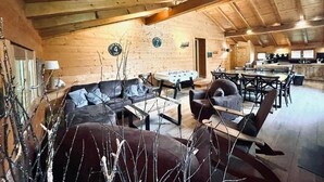 L’intérieur d’une cabane en rondins comprend un espace de vie, un coin repas et une cuisine ouverte.