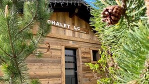Un chalet en bois avec une pancarte indiquant « CHALET 4C » et une porte noire.