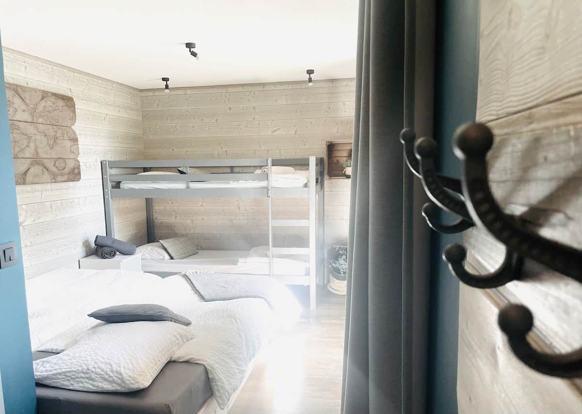 Una camera da letto moderna con una cuccetta, un comodino e una tenda.