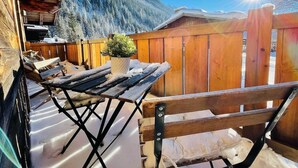 A wooden deck with a table and chairs, a potted plant, and a view of snow-covered mountains. - Chalet 14 pers, jacuzzi, MontBlanc view, 5 bedrooms (Chamonix)