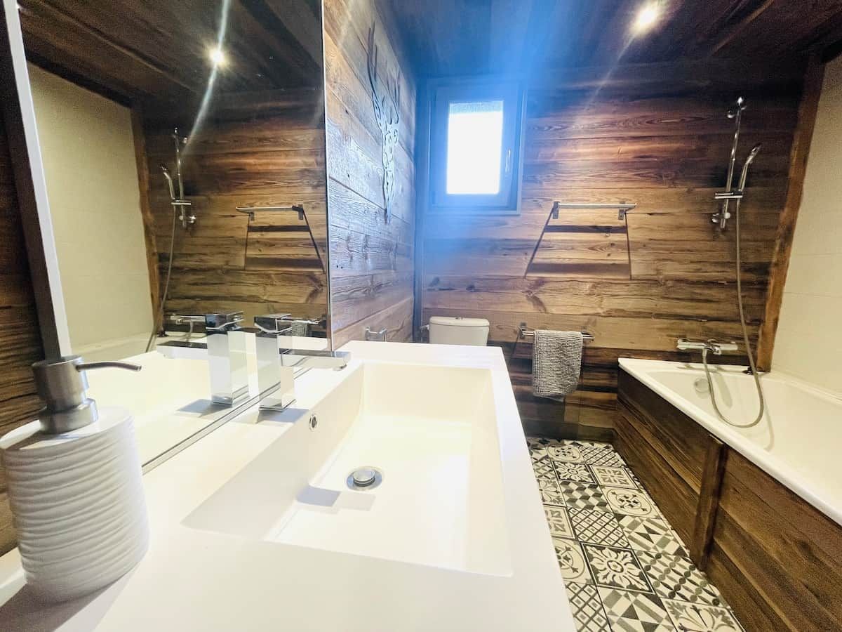 Un baño moderno con una bañera grande, dos lavabos y una ducha.