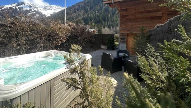 Un jacuzzi, mobiliario exterior y vistas a la montaña.