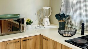 Une cuisine équipée d’un four à micro-ondes, d’un mixeur et d’une petite plante en pot.