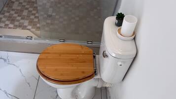 Een douche, handdoeken, zeep, toiletpapier