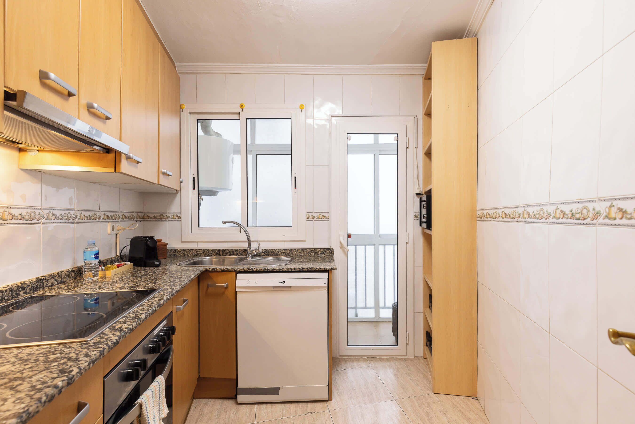 A compact kitchen with a dishwasher, stove, and a small countertop area.