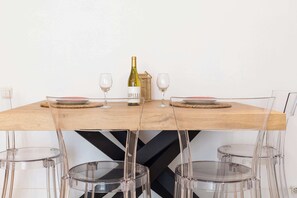 A dining table with a bottle of wine, two glasses, and plates. - City Center · Ritort - Unik Vacation (Tarragona)