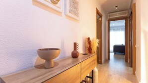 A hallway with a wooden console table, a bowl, a vase, and decorative items. - City Center · Ritort - Unik Vacation (Tarragona)