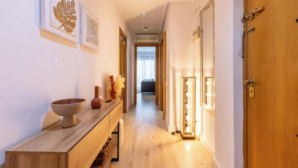 A hallway with a wooden bench, wall art, and a vanity with a mirror and lights. - City Center · Ritort - Unik Vacation (Tarragona)