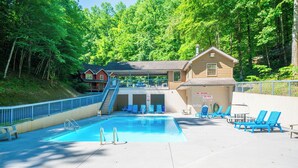 A swimming pool with lounge chairs, a no diving sign, and a building with a staircase. - Bear Cozy: Snuggle Up in the Smokies (Pigeon Forge)