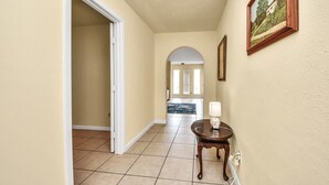 A hallway with a door, a lamp, and a painting on the wall. - Lofty Grace Home 3 - Houston (Houston)