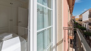 A balcony with a view of a narrow street, a white door, and a white railing. - LXR Atlantida 3-Bedroom Near the Ocean (Fuengirola)