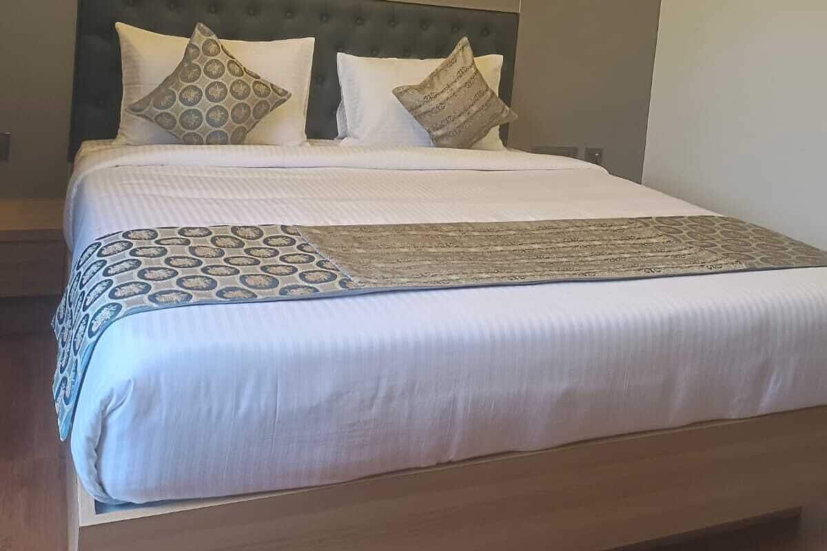 Una habitación de hotel moderna con una cama grande, una lámpara de techo redonda y un diseño minimalista.