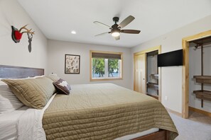 A bedroom with a bed, a ceiling fan, a window, a television, and a closet. - NEW! Fairway Views, Near Mille Lacs, Private Deck (Onamia)