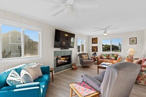 Ein Wohnzimmer mit Kamin, Fernseher und einer Couch.