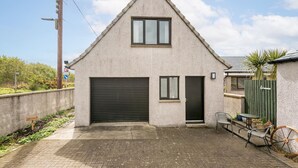 Ein eingeschossiges Geb äude mit Garage, einer kleinen Tür und einem Fenster.