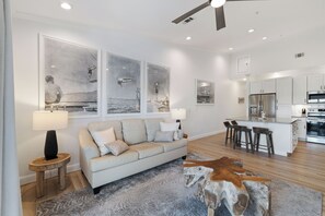 A modern living room with a sofa, a coffee table, and artwork on the wall.
