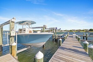 A boat docked at a pier with a wooden walkway and bollards.