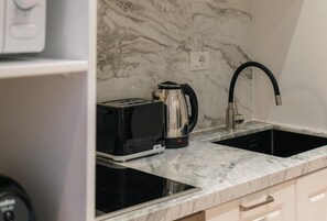 Máquina de café espresso, cafetera o tetera y frigorífico grande