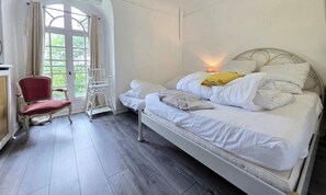 A bedroom with a bed, a chair, a window, and a lamp. - Spacious and peaceful villa - 15 guests (HERBEVILLE)