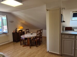 Un comedor con una mesa, sillas, una lámpara y un radiador.