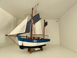Ein Modellschiff auf einem Holzständer, mit dem Schriftzug 'THONIER'.