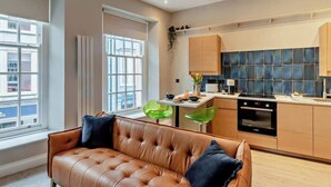 Een moderne keuken met een eethoek, een bank en een hanglamp.
