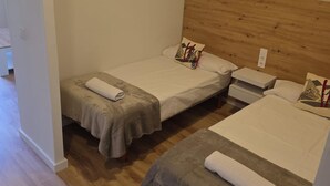A hotel room with two single beds, a wooden headboard, a small bedside table, and a nightstand. - Modern studio in Candanchú - 4 guests (Aisa-Candanchú)