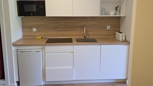 A compact kitchen with a microwave, sink, toaster, and a small refrigerator. - Modern studio in Candanchú - 4 guests (Aisa-Candanchú)