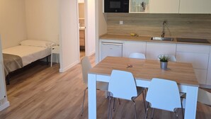 A compact kitchen with a microwave, sink, and a dining area with chairs. - Modern studio near slopes - 4 guests (Aisa-Candanchú)