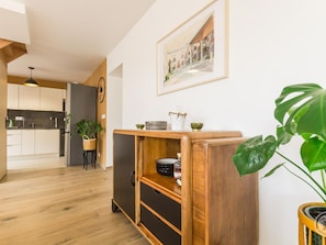 Eine moderne Küche mit Holzausbau, einem eingebauten Backofen und einem Essbereich mit einem Holztisch und Stühlen.