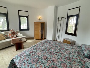 A bedroom with a bed, a sofa, a wardrobe, a ladder, and a wall-mounted light fixture. - Villa with private pool and air conditioning - 8 guests (Miami Playa)