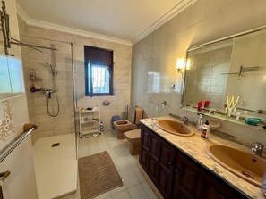 Ein Badezimmer mit Dusche, Toilette, Waschbecken und Waschtisch.