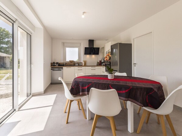 A modern kitchen with white cabinets, a built-in oven, and a large window.