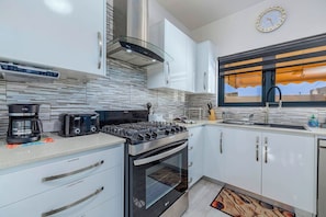 Eine moderne Küche mit Gasherd, Backofen, Kaffeemaschine und Toaster.