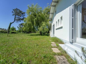 A grassy area with a pathway leading to a building with large windows. - Spacious house near the lake - 6 guests (Mimizan)