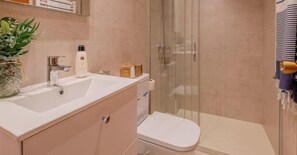 Un baño con lavamanos, inodoro y ducha.
