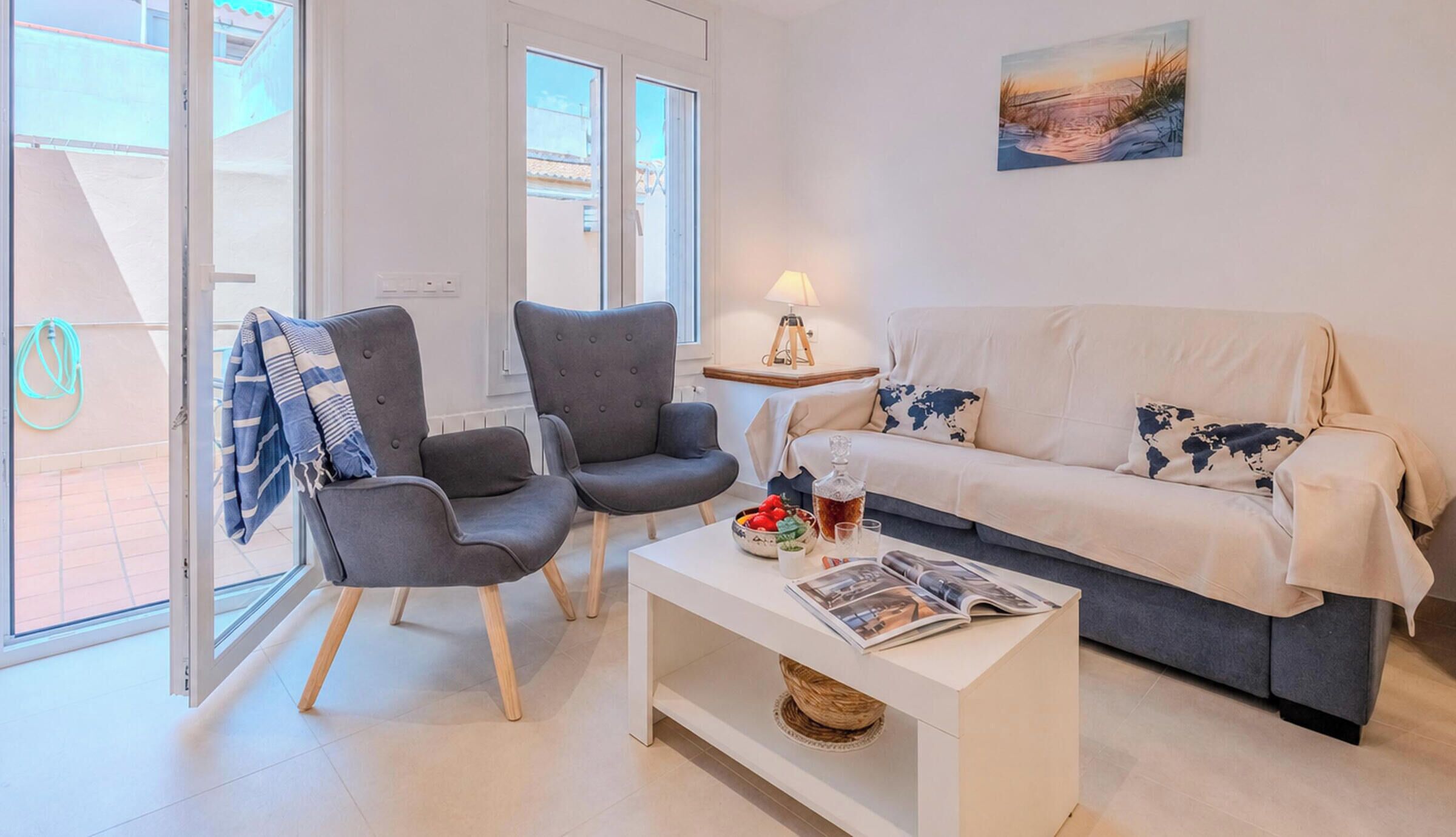 A modern living room with a sofa, two armchairs, a coffee table, and a painting on the wall.