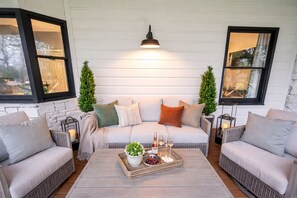 A cozy seating area with a sofa, two armchairs, a coffee table with a tray of snacks and drinks, and a pendant light. - Private Mtn Top Inn • 110 ppl Weddings, Retreats & Events (Sevierville)