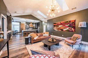 A spacious living room with a large sofa, a coffee table, and a patterned rug. - Private Mtn Top Inn • 110 ppl Weddings, Retreats & Events (Sevierville)