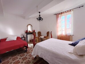 A room with two beds, a chandelier, a mirror, and a window with curtains. - Spacious house by the Canal - 14 guests (Argeliers)
