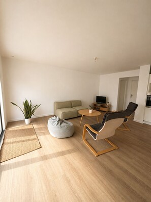 Ein modernes Wohnzimmer mit einer Couch, einem Couchtisch, einem Sitzsack und zwei Lounge-Sesseln.