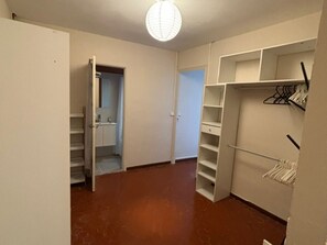 A room with a closet, a door leading to another room, and a light fixture on the ceiling. - Cozy apartment in city center - 2 guests (Narbonne)