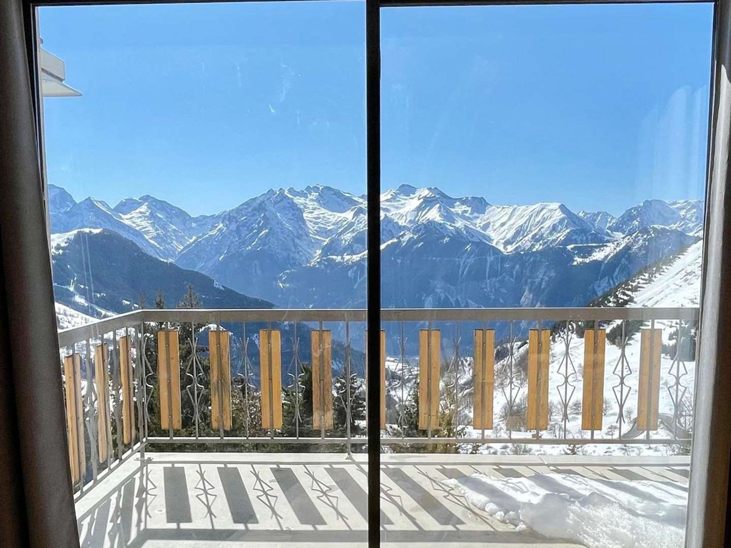 A balcony with a view of snow-covered mountains.