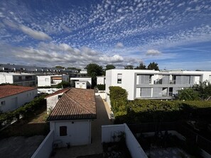 Un quartier résidentiel avec des maisons modernes, un ciel dégagé et quelques arbres.