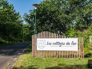 Ein Schild mit der Aufschrift 'Les cottages du lac' und einem Logo, das eine Unterkunft kennzeichnet.