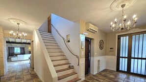 A staircase leading to a second floor, a chandelier, and a large window with blinds. - House with pool, pets allowed - 12 guests (Monsaguel)