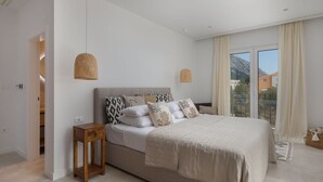 A bedroom with a bed, bedside tables, and a view of the outdoors. - Villa Vespera (Makarska)
