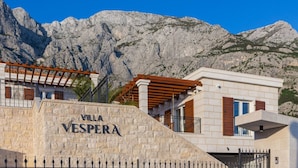 Villa Vespera with stone facade, wooden pergola, and mountainous backdrop. - Villa Vespera (Makarska)