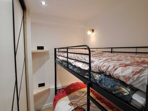 A bunk bed with two levels, a wall-mounted shelf, and a ceiling light. - Studio with slope view - 5 guests (La Toussuire)