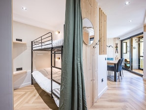 A bunk bed room with a desk and chair, a mirror, and a view through a glass door. - Studio with slope view - 5 guests (La Toussuire)